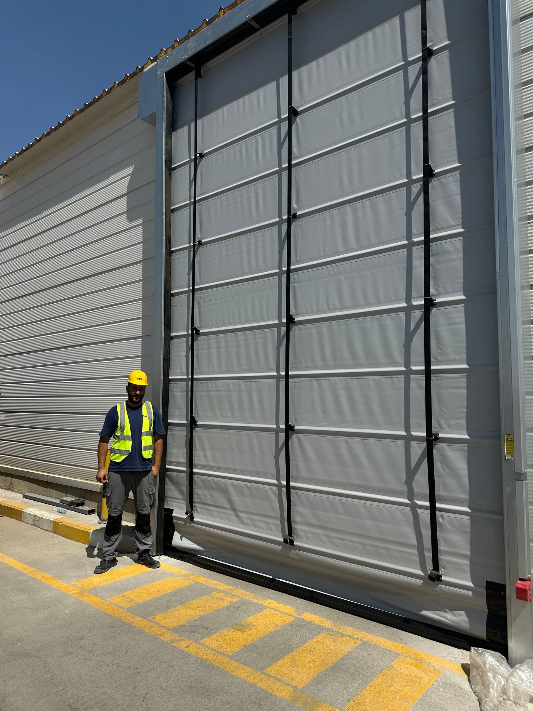 Row of industrial sectional doors along a warehouse loading facade