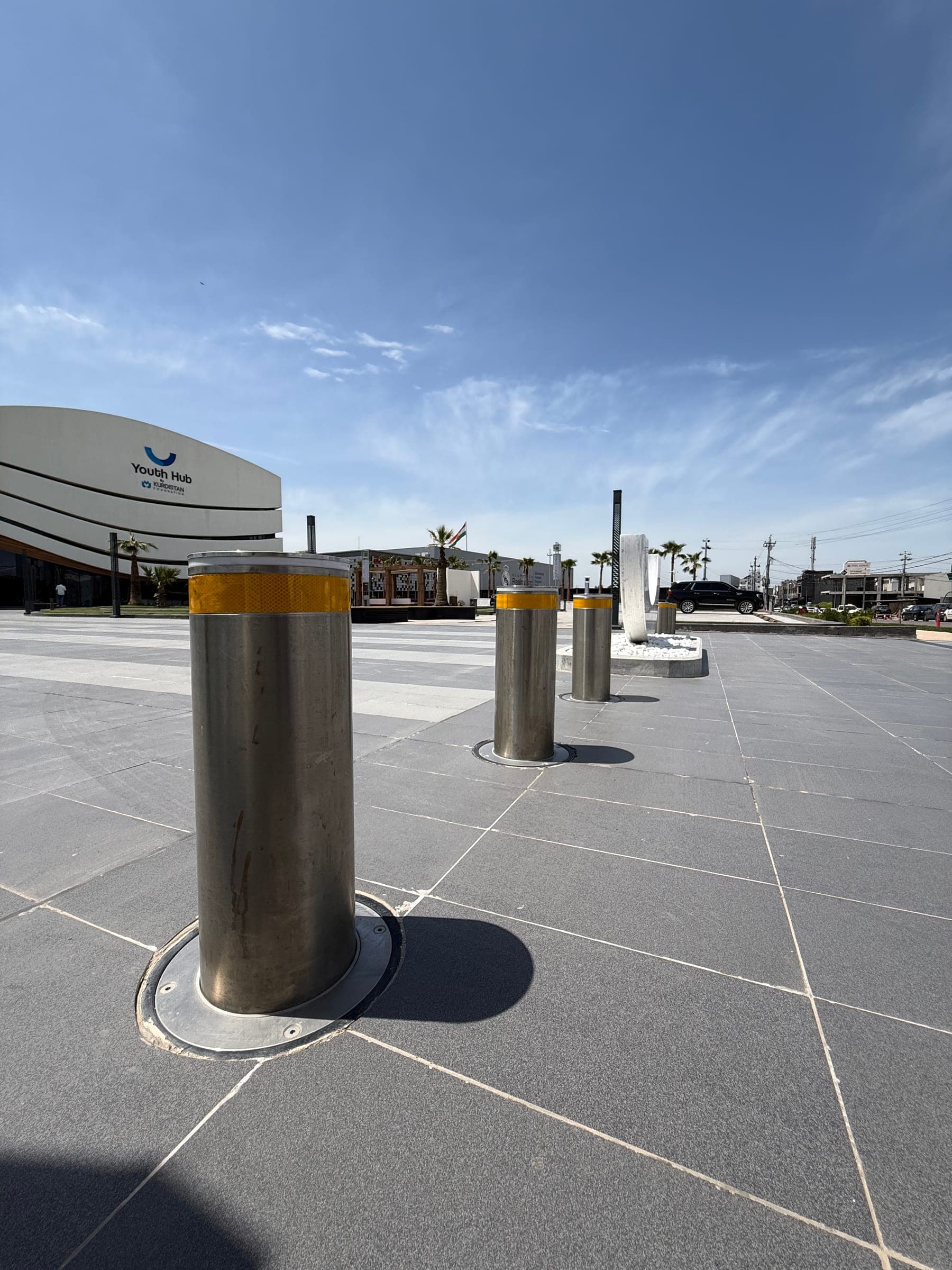 Illuminated retractable bollards protecting the forecourt of a modern building